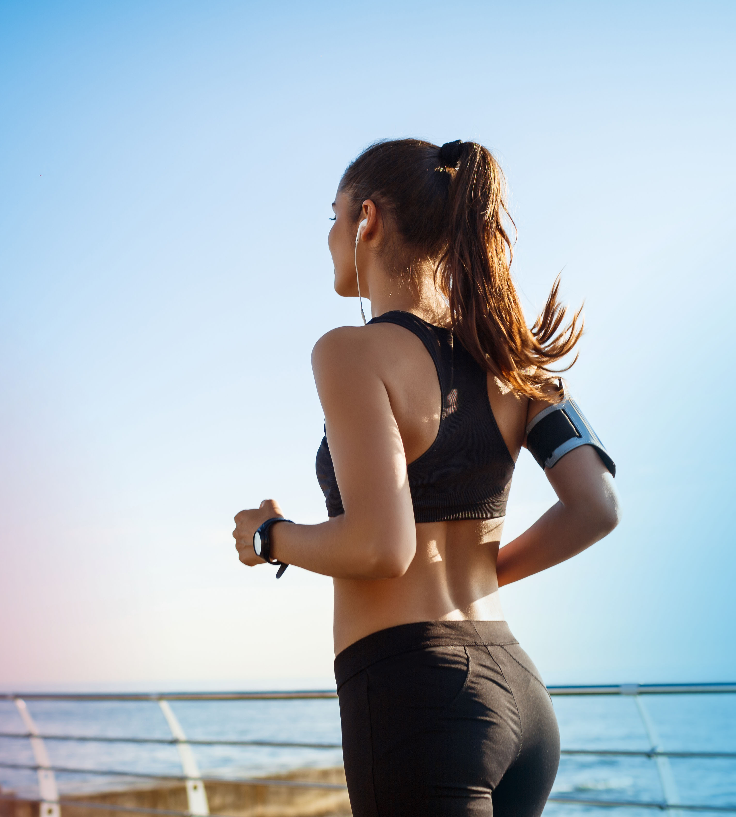 Picture of young attractive fitness girl jogging with sea on background -  Trinity Hospice